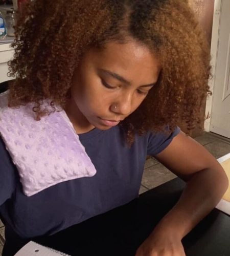 Person using a lavender heating pad by Mumu Wraps while studying at home